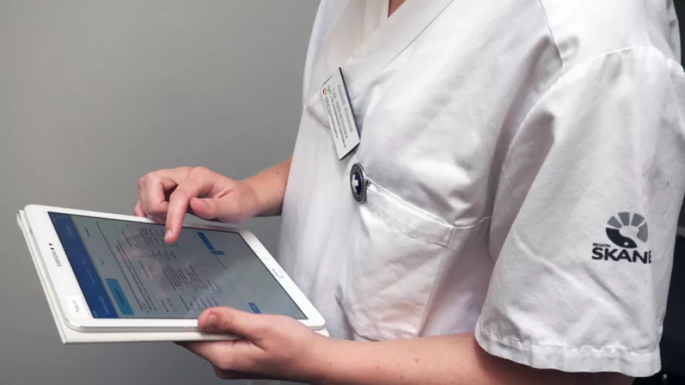 Sjuksköterska håller i en e-platta