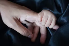 Barn håller vuxens hand