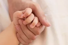 Förälder håller ett barns hand. Foto.